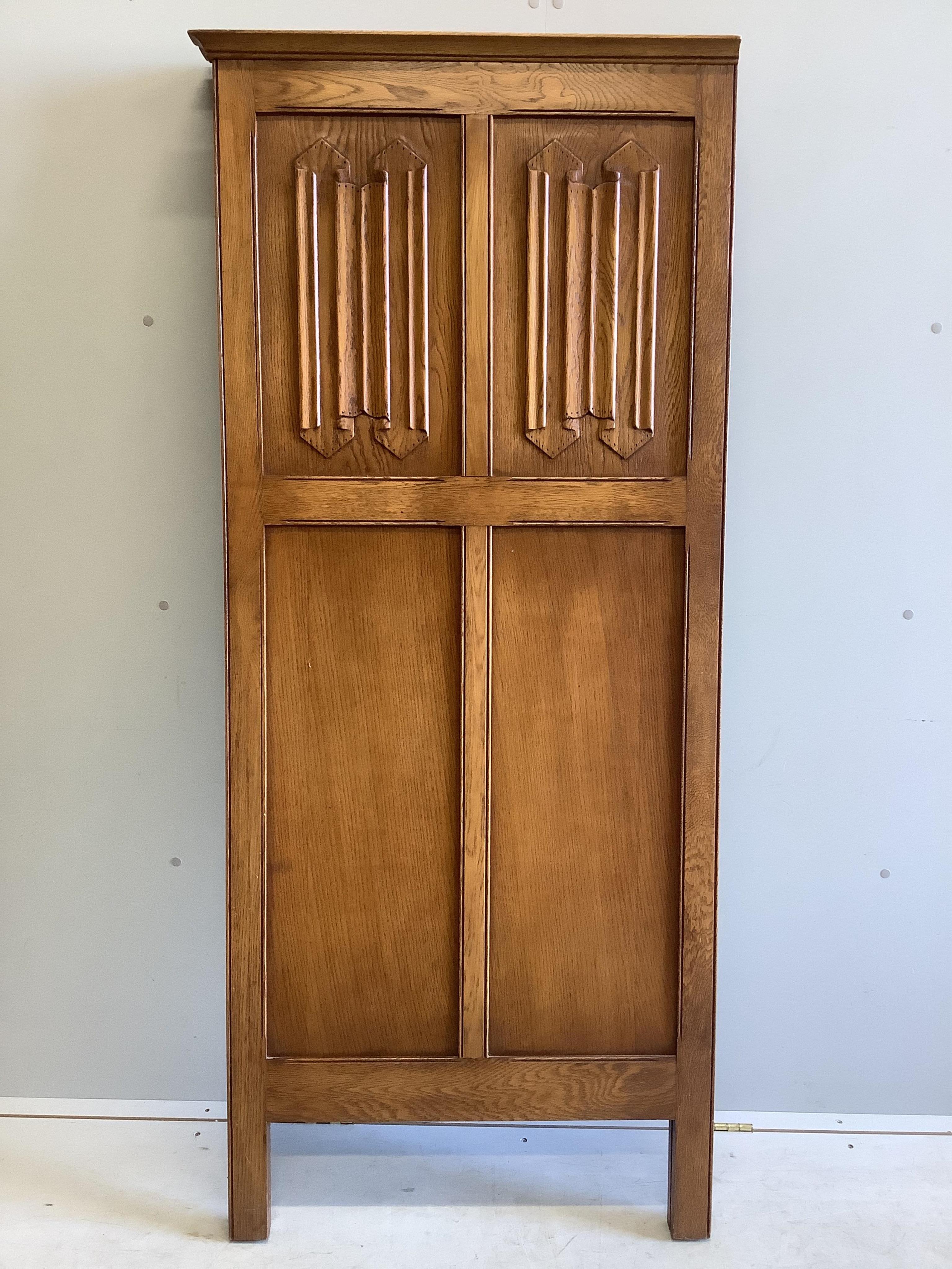 An early 20th century carved oak linen fold two fold dressing screen, each panel width 73cm, height 170cm. Condition - good